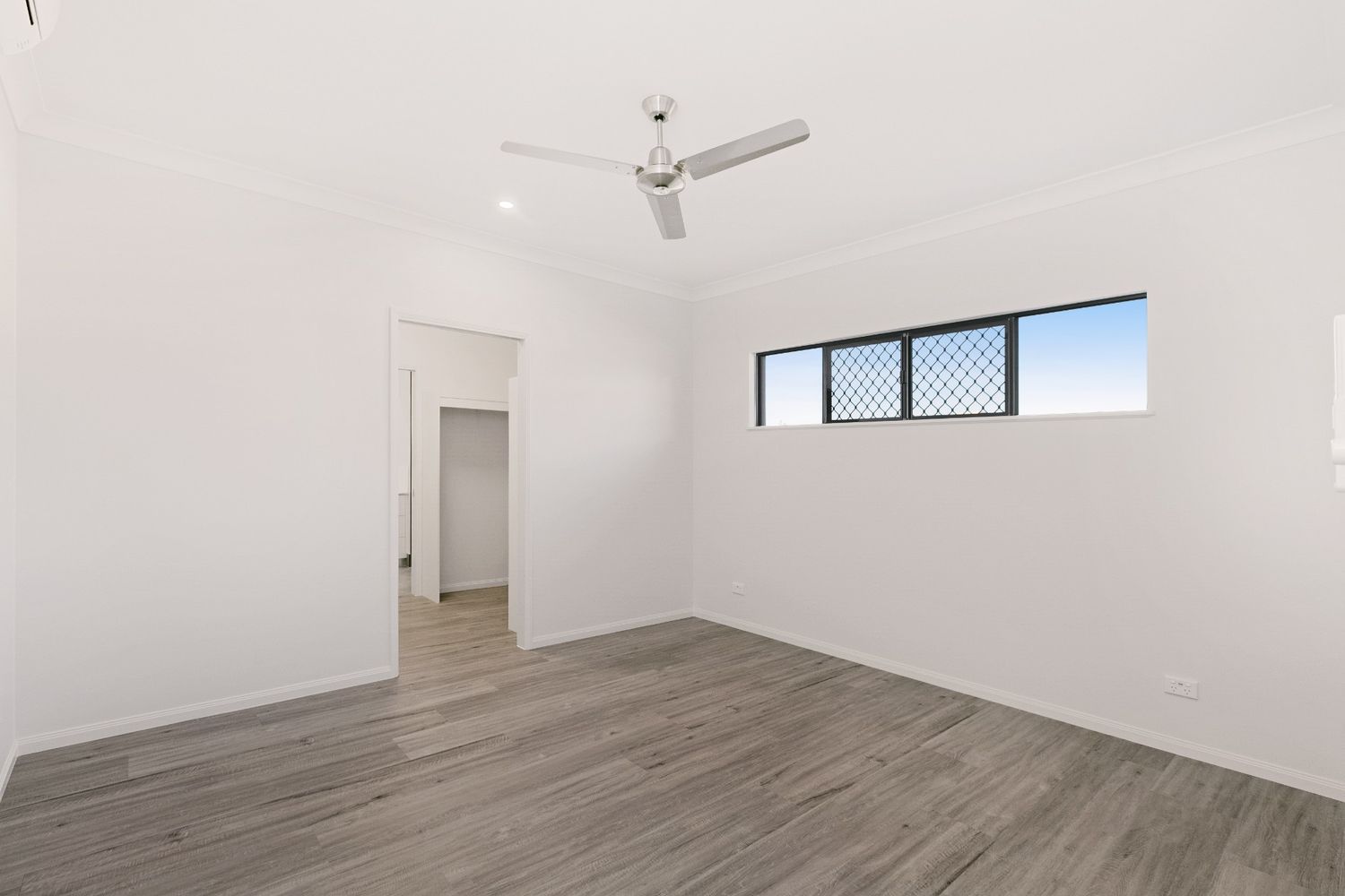 An Empty Room With a Ceiling Fan and a Window — Ashlee Jones Homes in Gordonvale, QLD
