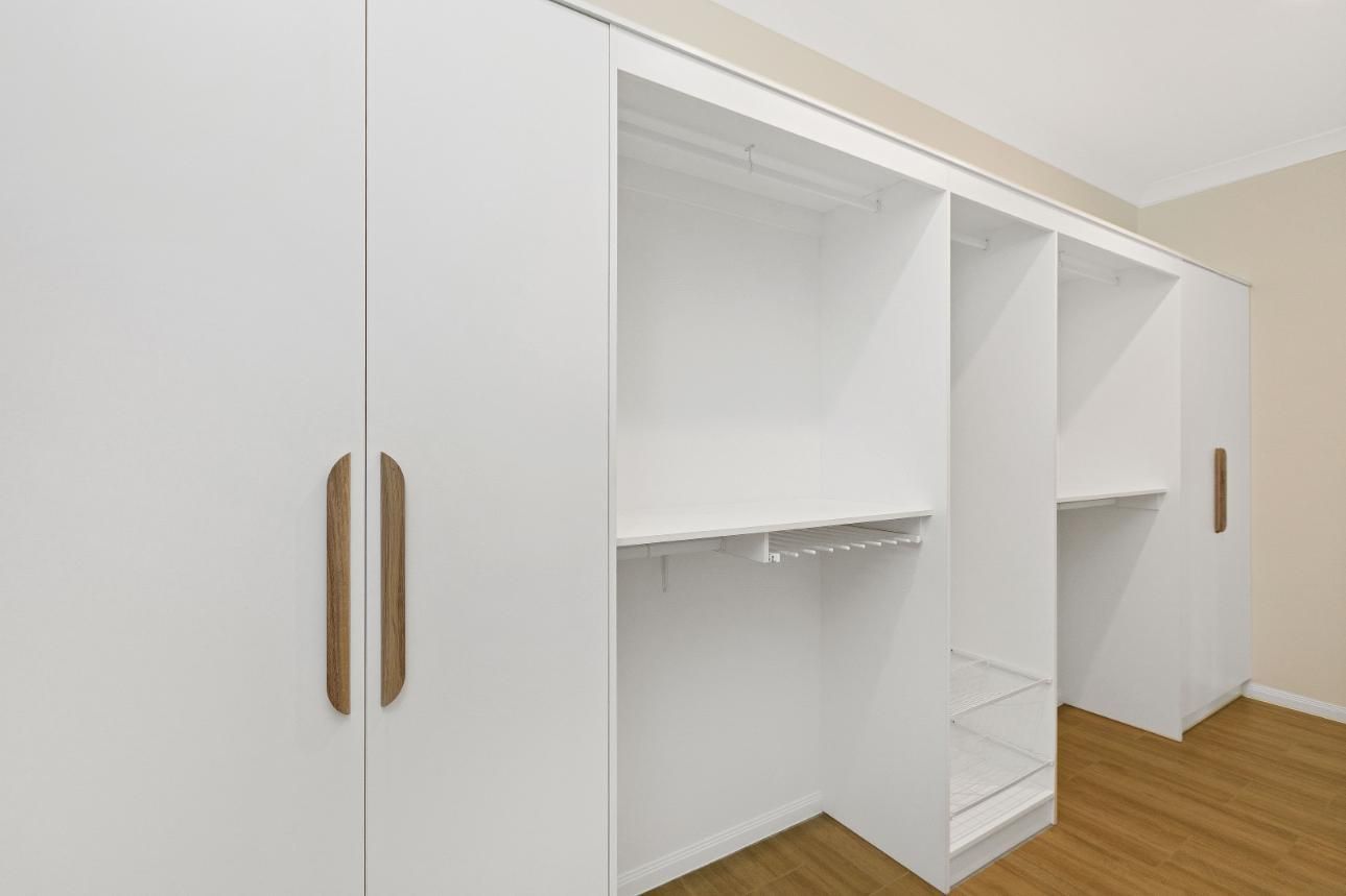 A Room With a Lot of White Cabinets and Wooden Floors— Ashlee Jones Homes in Gordonvale, QLD