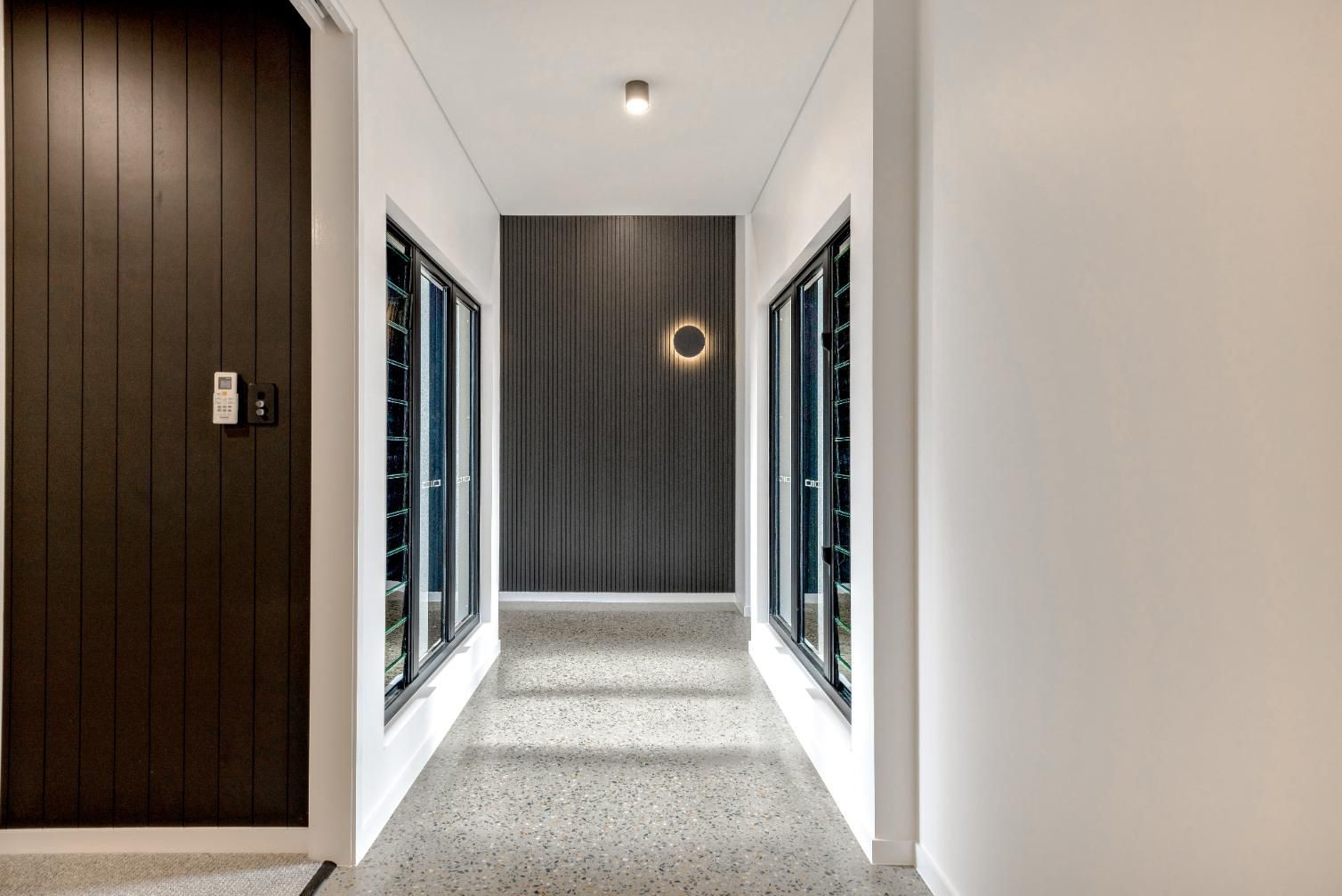 It Is a Long Hallway with A Lot of Windows and A Door — Ashlee Jones Homes in Gordonvale, QLD