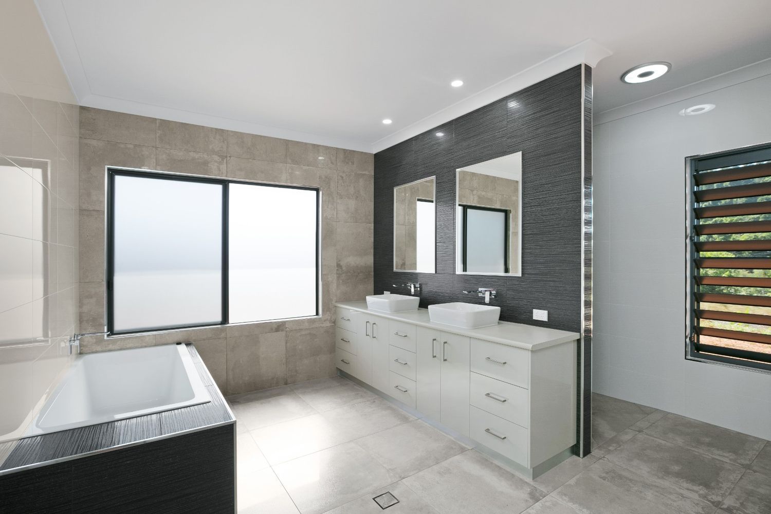 A Bathroom With Two Sinks, Two Mirrors and a Bathtub — Ashlee Jones Homes in Gordonvale, QLD