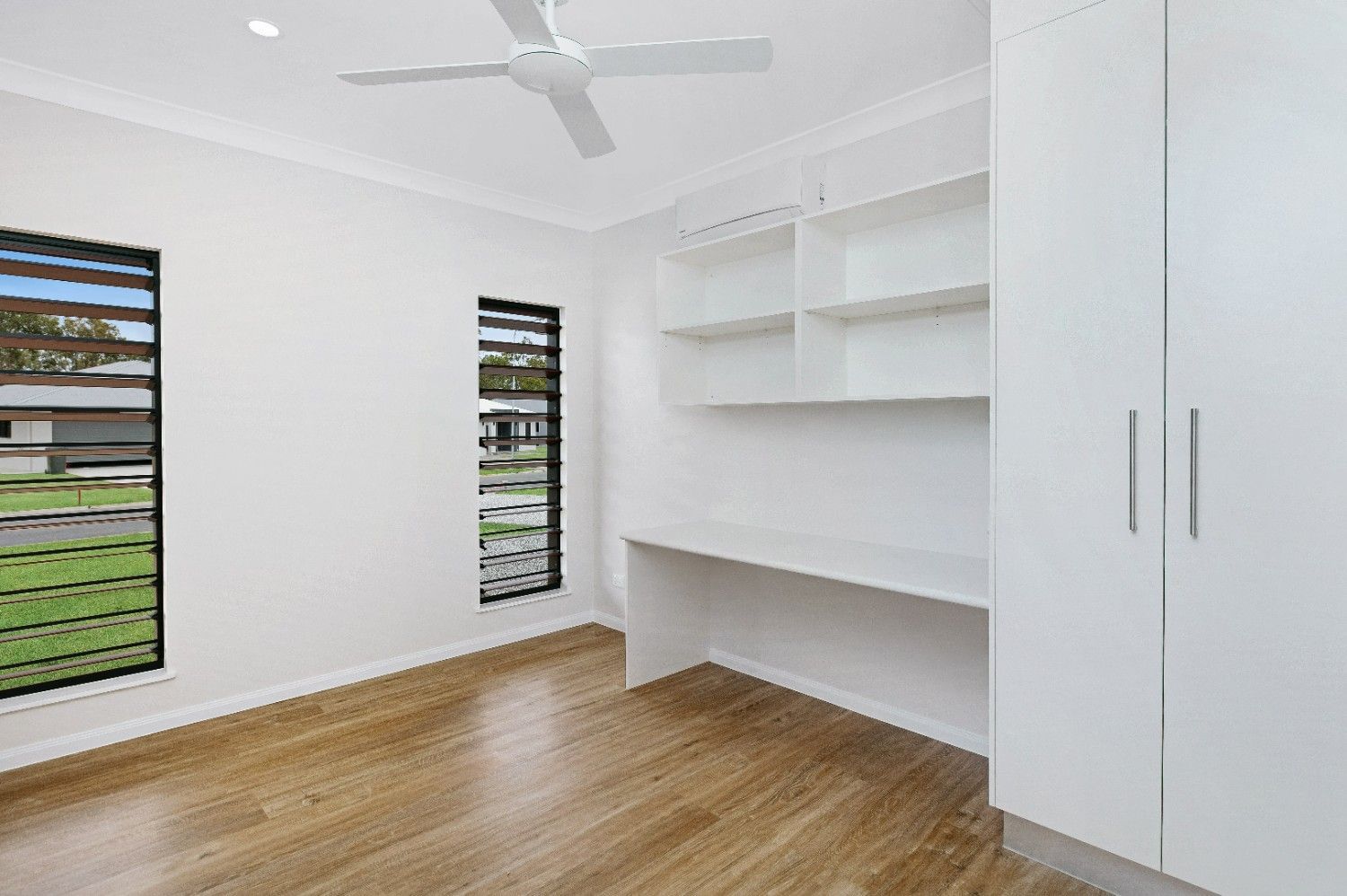 An Empty Room With a Desk and a Ceiling Fan — Ashlee Jones Homes in Gordonvale, QLD