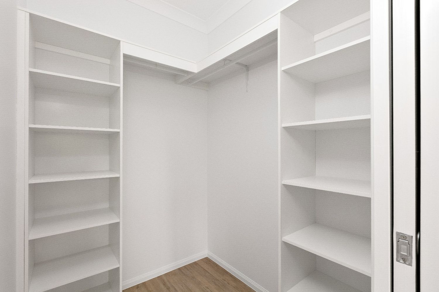 A Walk in Closet With Lots of Shelves and a Door — Ashlee Jones Homes in Gordonvale, QLD