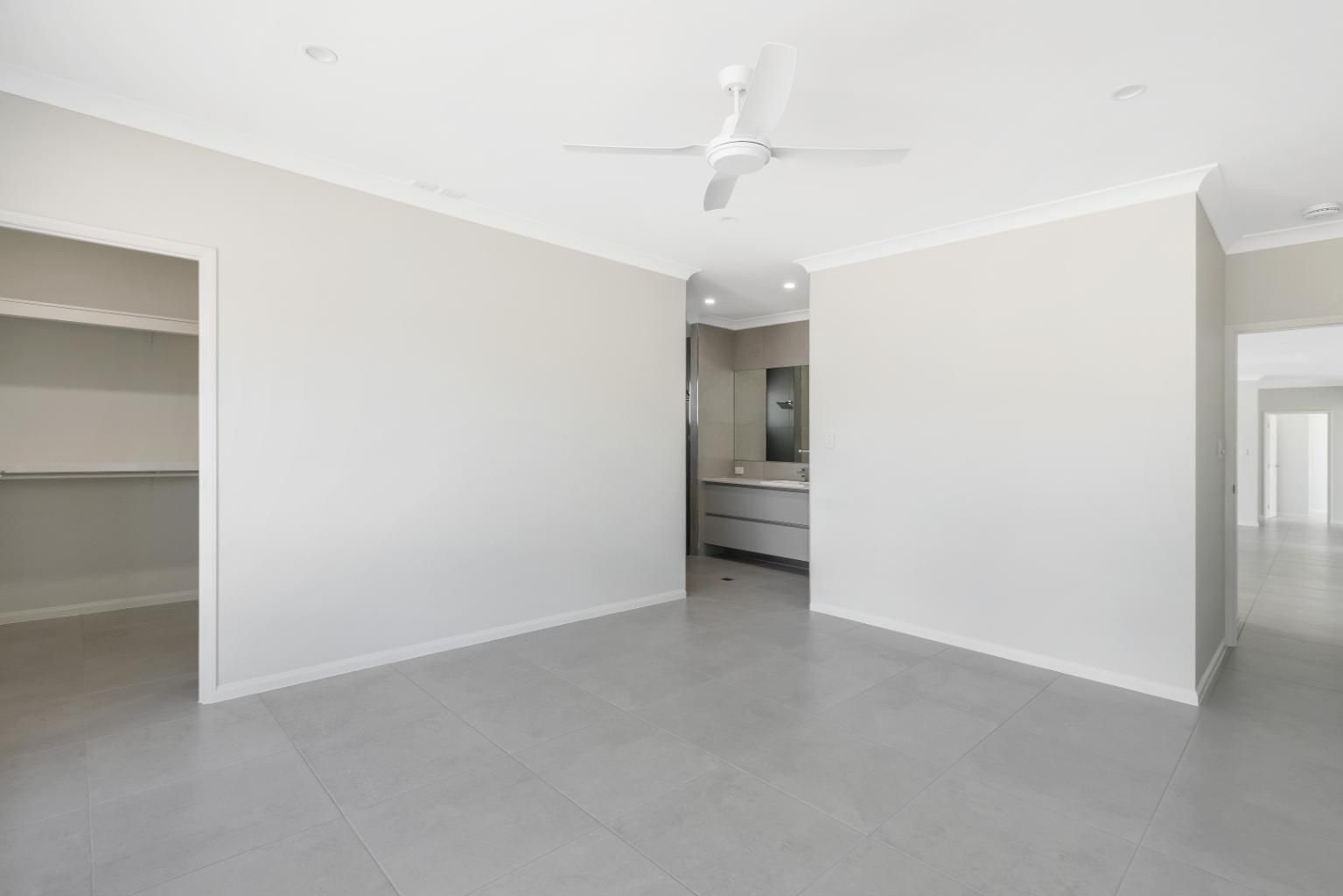 An Empty Room With White Walls and a Ceiling Fan — Ashlee Jones Homes in Gordonvale, QLD