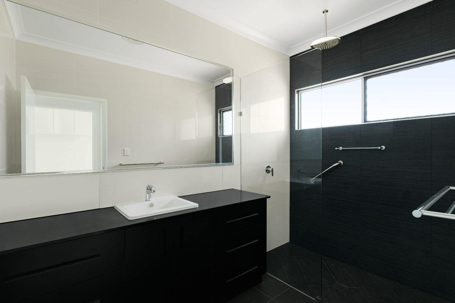 A Bathroom With a Sink a Mirror and a Walk in Shower — Ashlee Jones Homes in Gordonvale, QLD