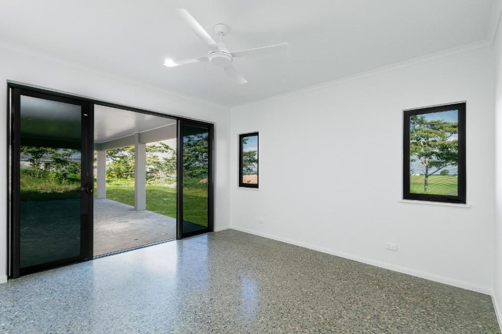 An Empty Room With Sliding Glass Doors and a Ceiling Fan — Ashlee Jones Homes in Gordonvale, QLD