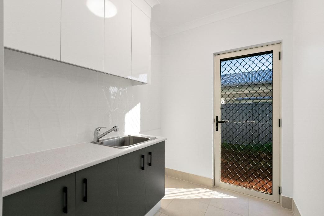 A Kitchen With a Sink, Cabinets, and a Door — Ashlee Jones Homes in Gordonvale, QLD