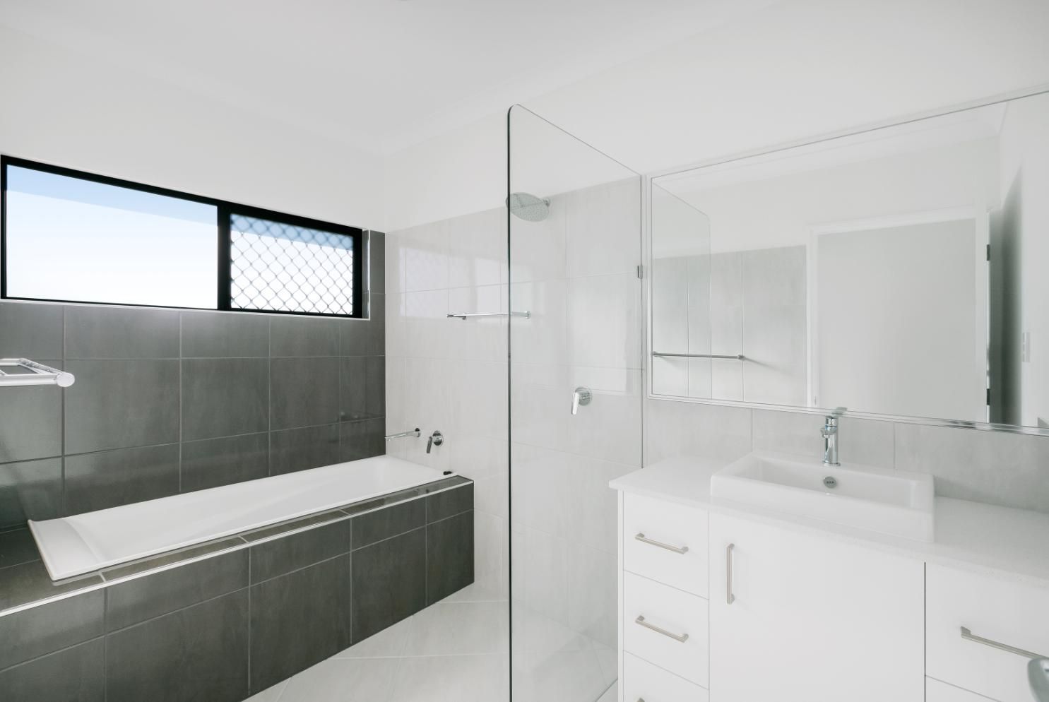 A Bathroom With a Bathtub a Sink and a Walk in Shower — Ashlee Jones Homes in Gordonvale, QLD