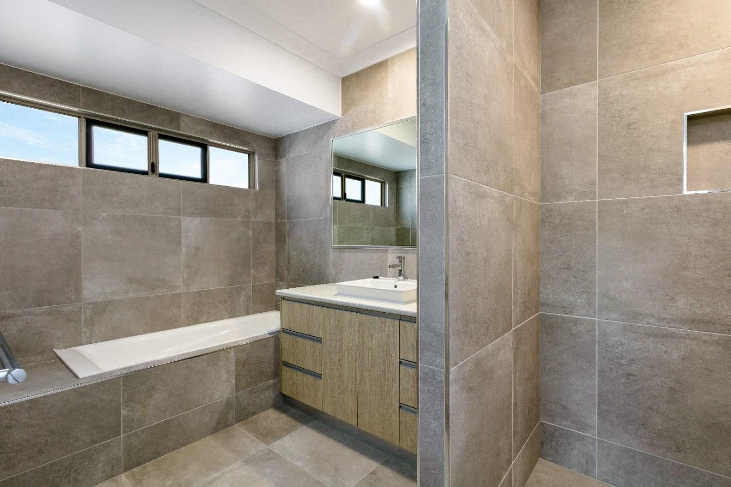 A Bathroom With a Bathtub, Sink, and Shower — Ashlee Jones Homes in Gordonvale, QLD