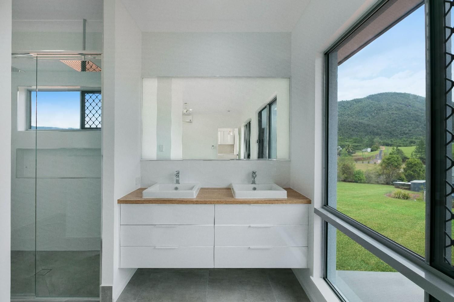 A Bathroom With Two Sinks and a Large Window — Ashlee Jones Homes in Gordonvale, QLD