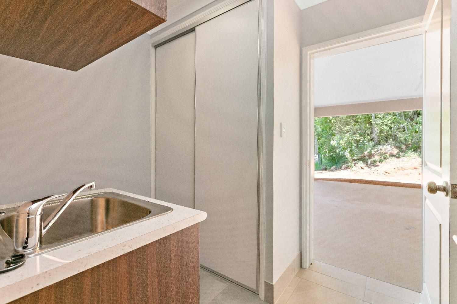 A Kitchen With a Sink and a Door That is Open — Ashlee Jones Homes in Gordonvale, QLD