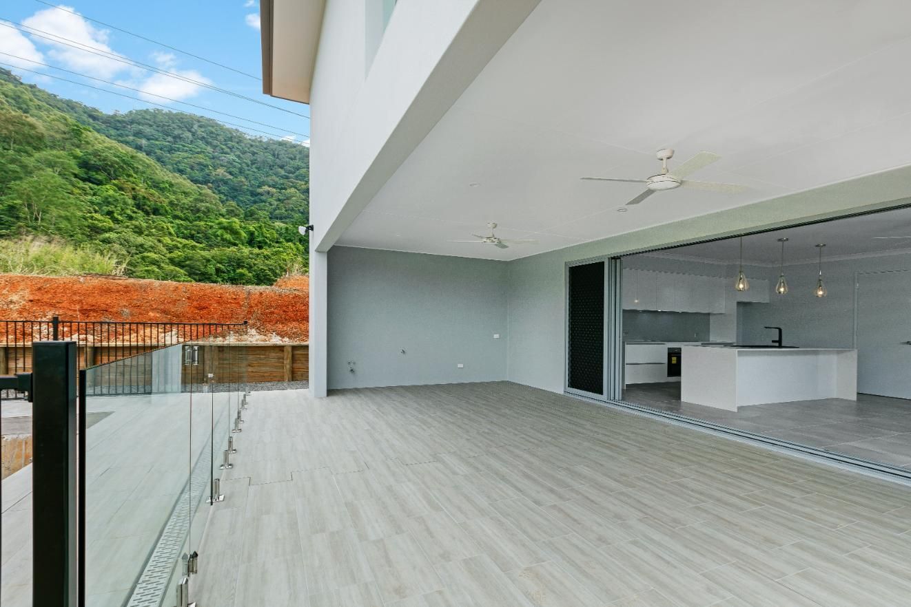 Patio With Sliding Glass Doors Leading to a Kitchen and Mountains in the Background — Ashlee Jones Homes in Gordonvale, QLD