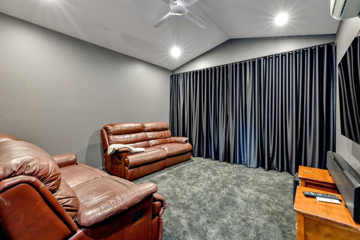 A Living Room With a Couch, Chairs and a Television — Ashlee Jones Homes in Gordonvale, QLD