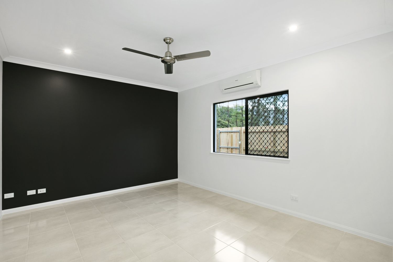 An Empty Room With a Ceiling Fan and a Window — Ashlee Jones Homes in Gordonvale, QLD