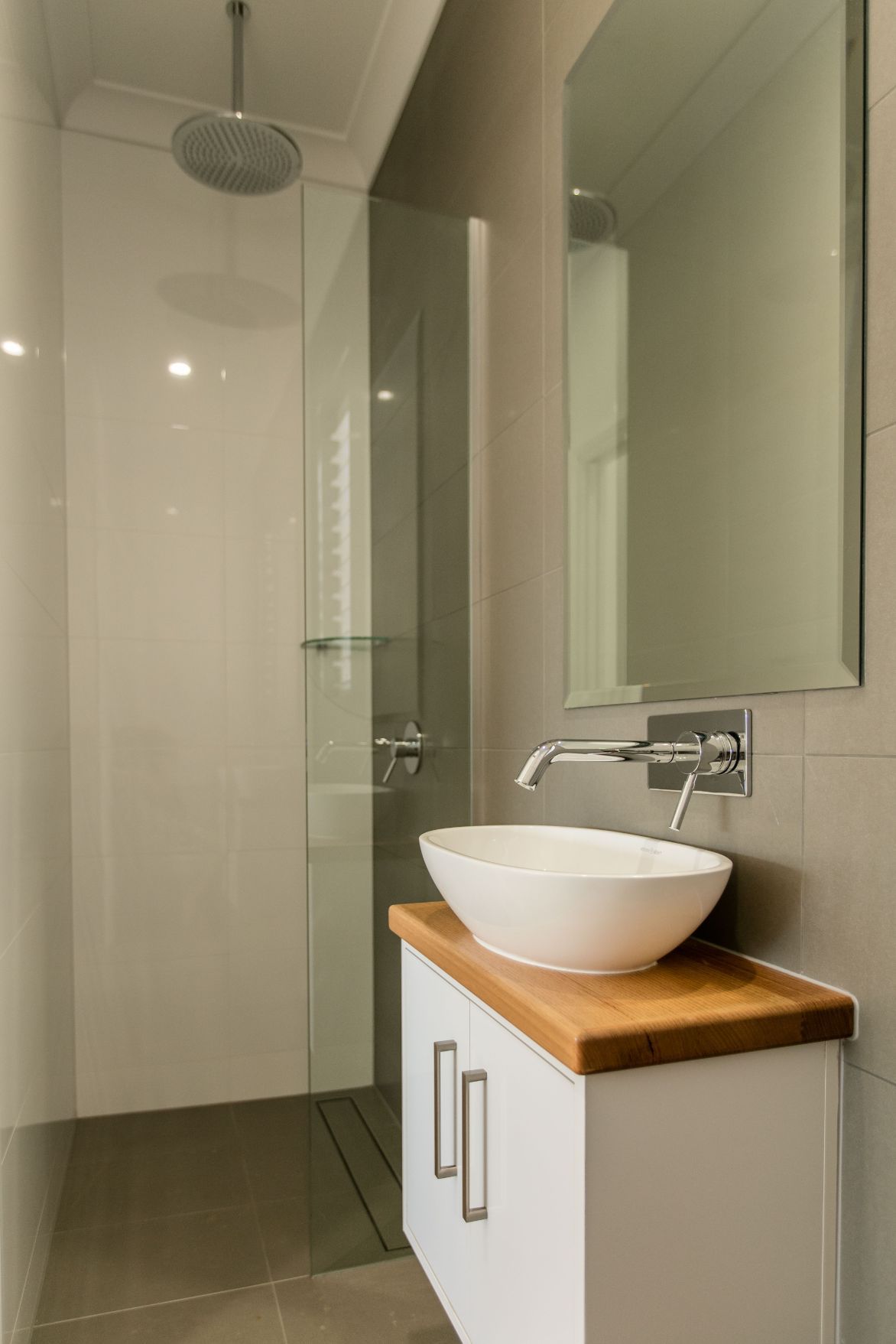 A Bathroom With a Sink, Mirror and Shower — Ashlee Jones Homes in Gordonvale, QLD