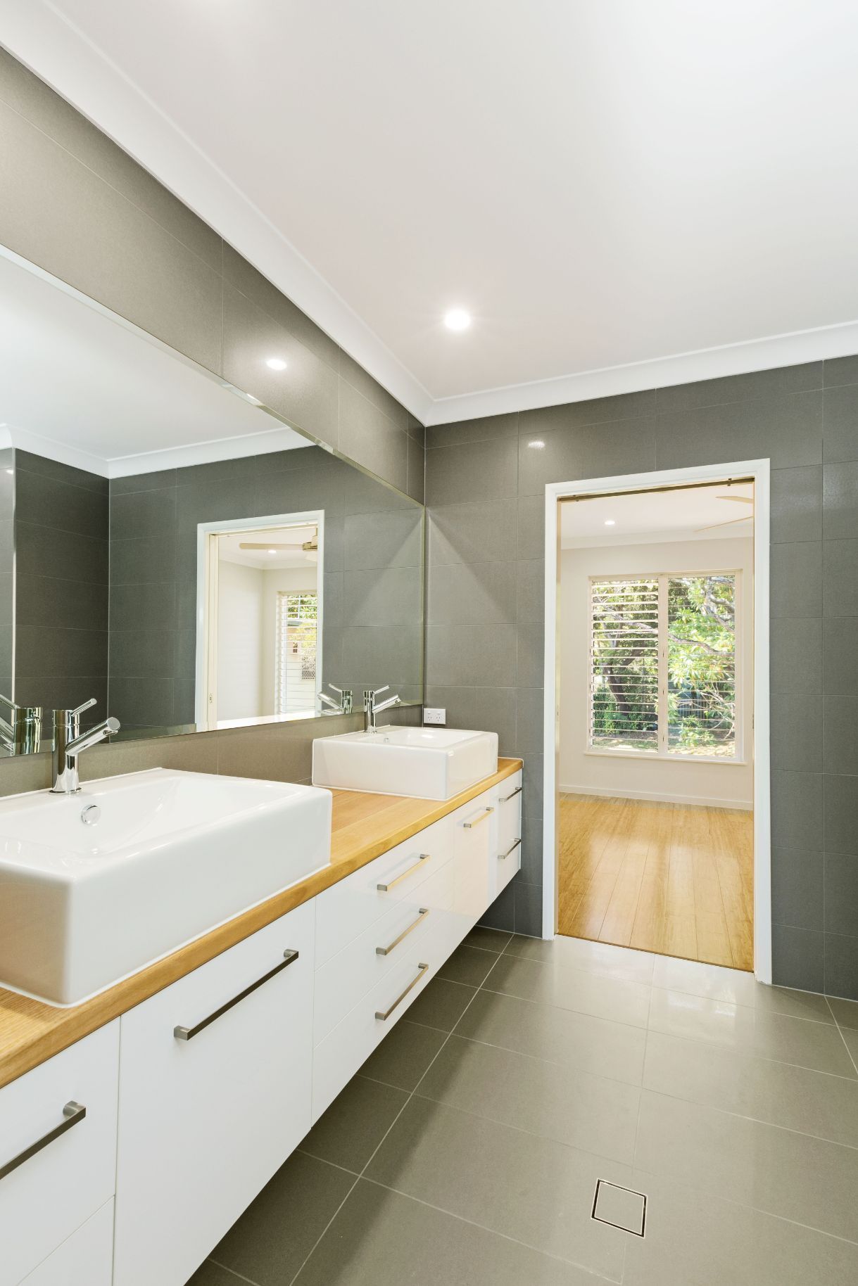 A Bathroom With Two Sinks and a Large Mirror — Ashlee Jones Homes in Gordonvale, QLD