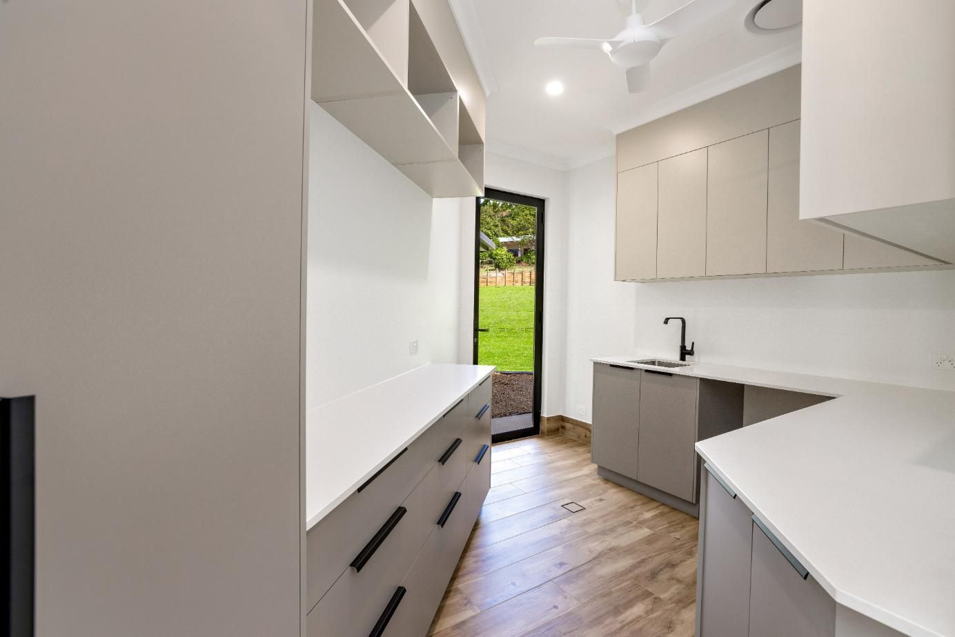 A Kitchen With a Sink, Cabinets , and a Sliding Glass Door — Ashlee Jones Homes in Gordonvale, QLD