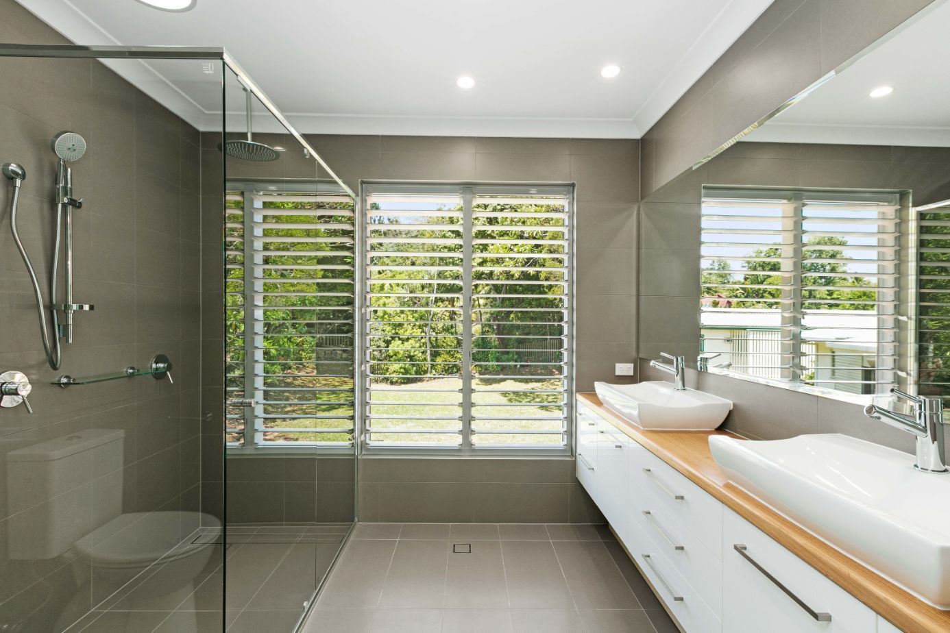 A Bathroom With Two Sinks and a Walk in Shower — Ashlee Jones Homes in Gordonvale, QLD