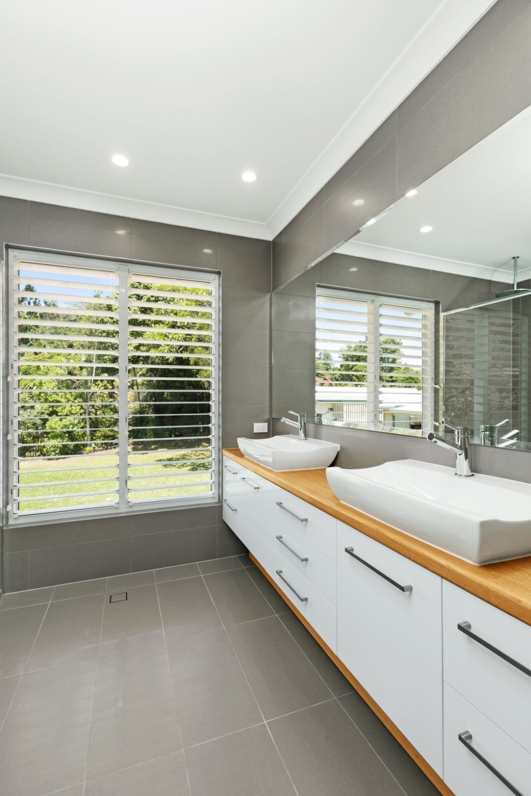 A Bathroom With Two Sinks and a Large Mirror — Ashlee Jones Homes in Gordonvale, QLD