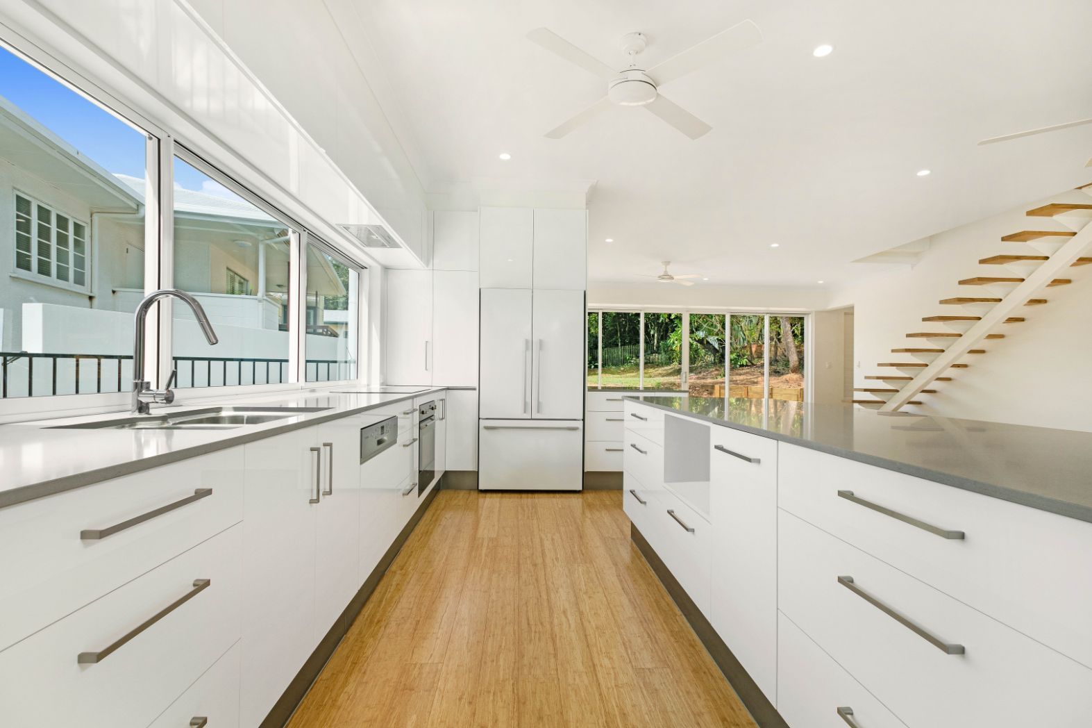 A Kitchen With White Cabinets and a Ceiling Fan — Ashlee Jones Homes in Gordonvale, QLD