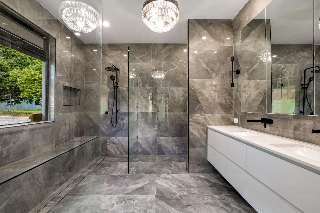 A Bathroom With a Walk in Shower, Sink, Mirror and Window — Ashlee Jones Homes in Gordonvale, QLD
