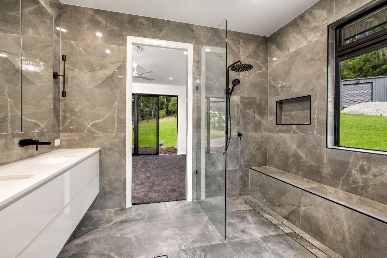 A Bathroom With a Walk in Shower, Sink, Mirror and Window — Ashlee Jones Homes in Gordonvale, QLD