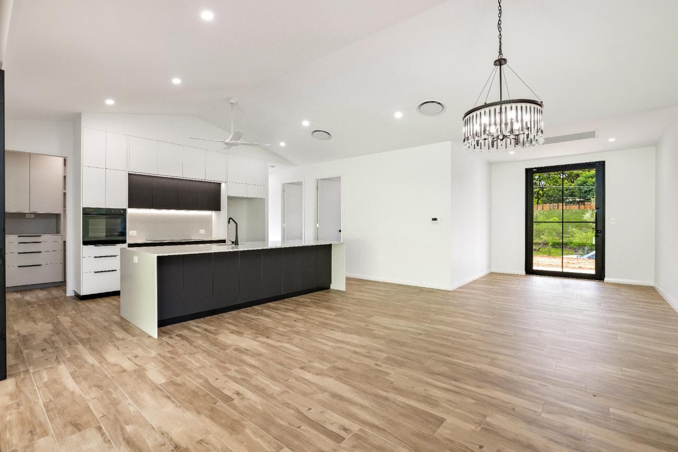 An Empty Kitchen With a Large Island in the Middle of the Room — Ashlee Jones Homes in Gordonvale, QLD
