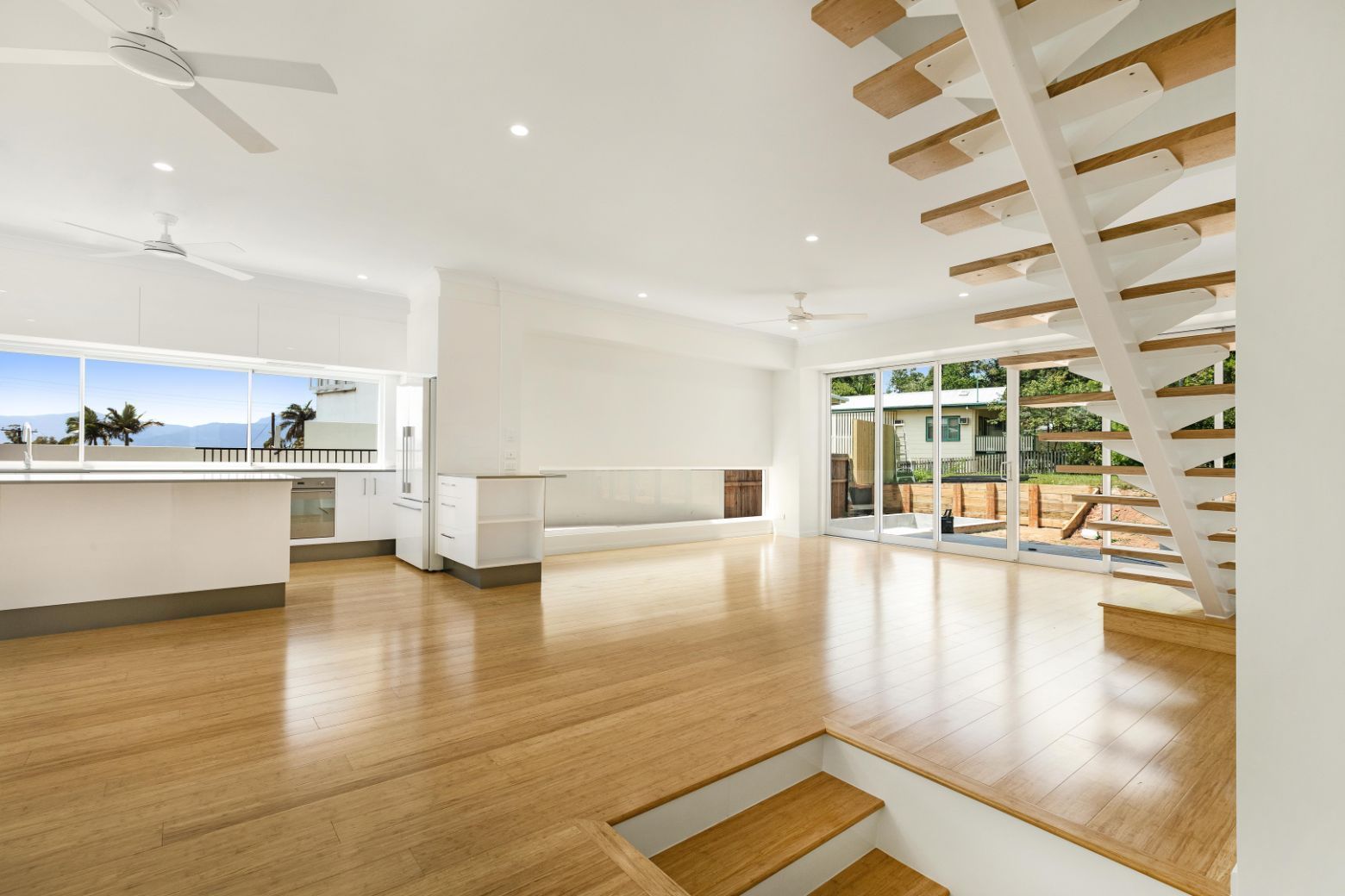 An Empty House With a Wooden Floor and Stairs — Ashlee Jones Homes in Gordonvale, QLD