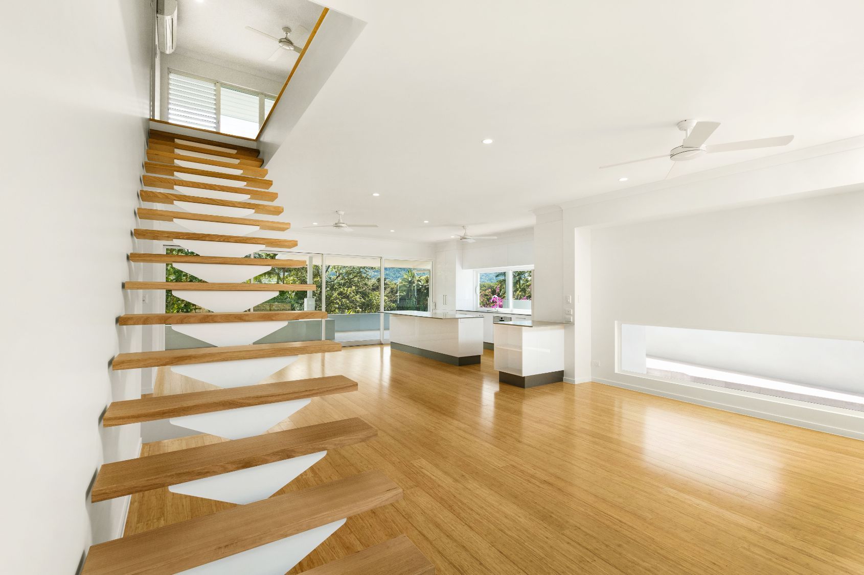 An Empty Room With a Wooden Staircase Leading Up to the Second Floor — Ashlee Jones Homes in Gordonvale, QLD