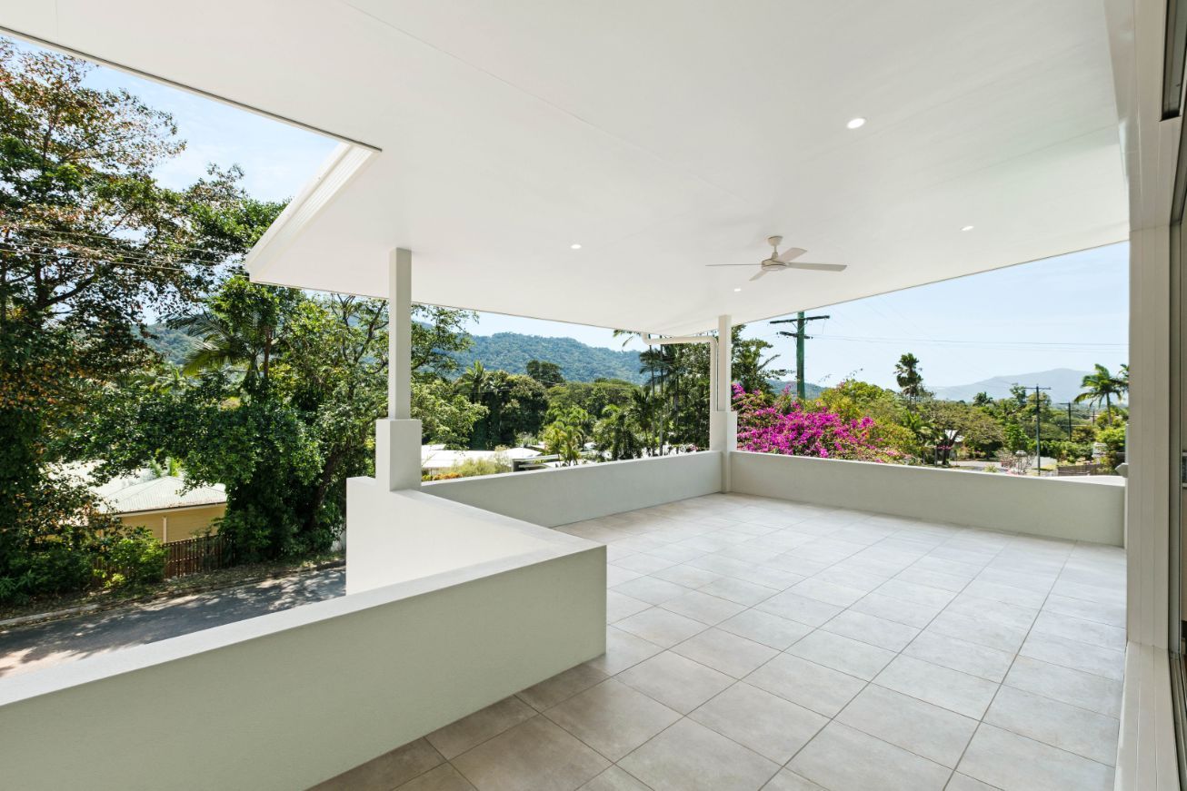 A Large Patio With a Ceiling Fan and a View of Trees and Mountains — Ashlee Jones Homes in Gordonvale, QLD