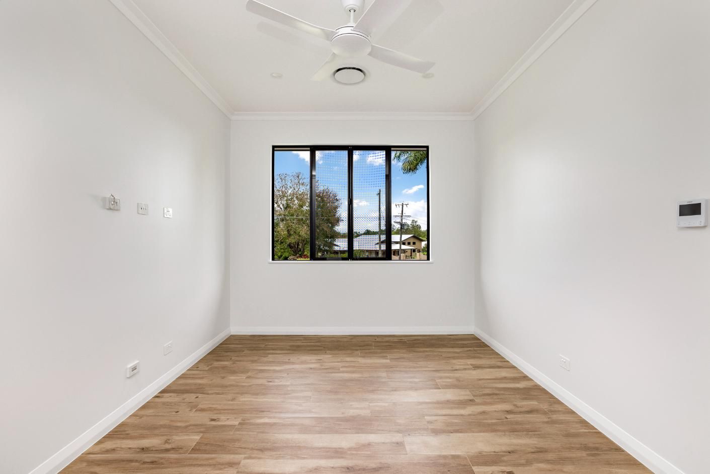 An Empty Room With a Ceiling Fan and a Window — Ashlee Jones Homes in Gordonvale, QLD