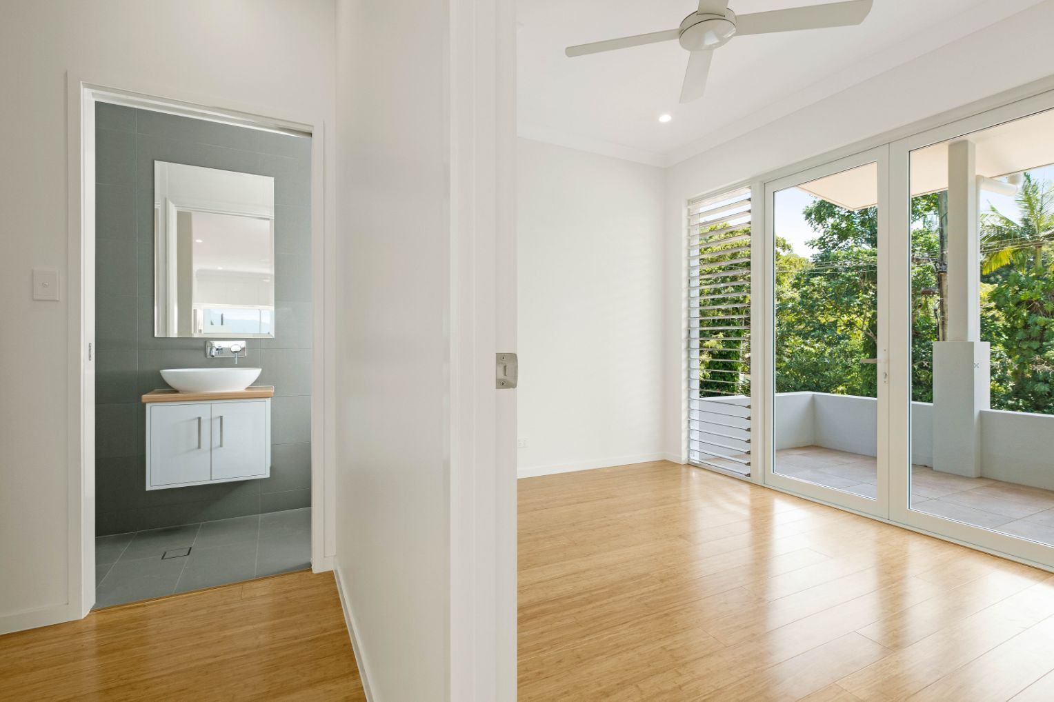 An Empty Room With a Bathroom and a Ceiling Fan — Ashlee Jones Homes in Gordonvale, QLD