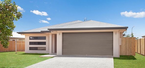 A White House With a Garage Door and a Wooden Fence — Ashlee Jones Homes in Gordonvale, QLD