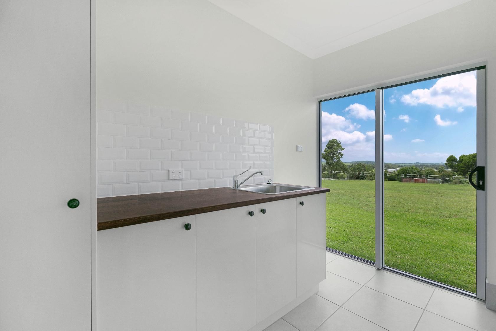 A Kitchen With a Sink and a Large Window With a View of a Field — Ashlee Jones Homes in Gordonvale, QLD