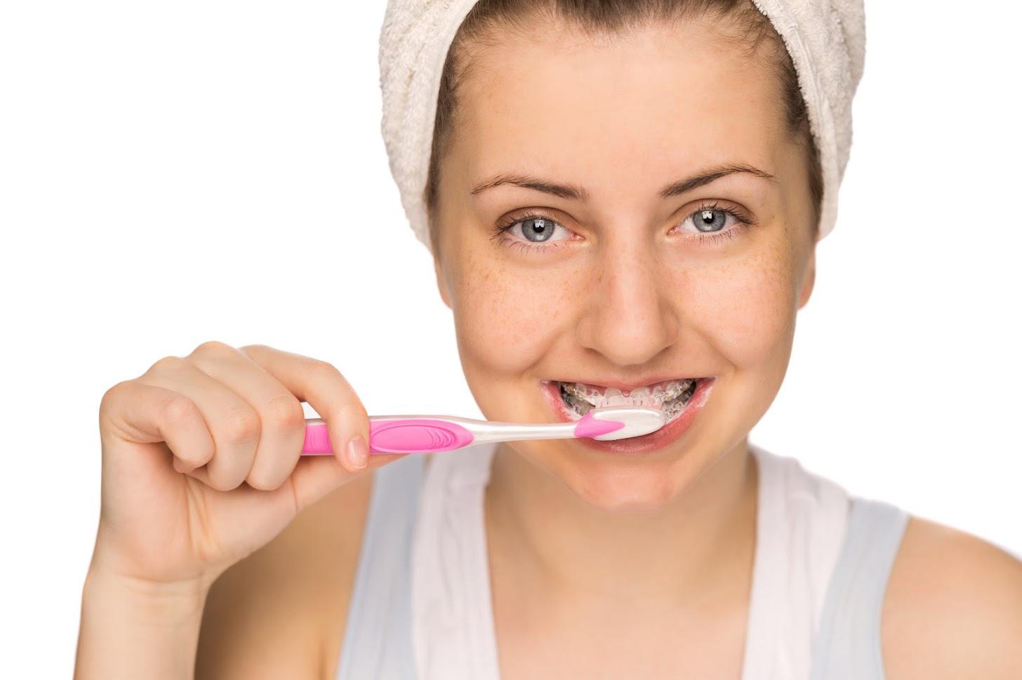 A Woman Cleaning Her Teeth — Fresno, CA — Donald E. Snyder Orthodontics