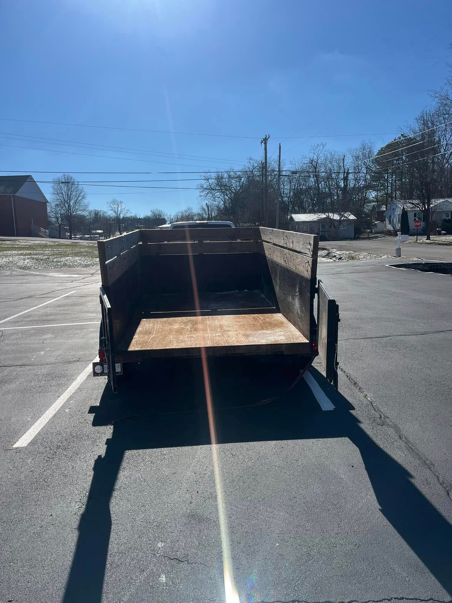 Trailer parked in a paved lot under a bright blue sky.