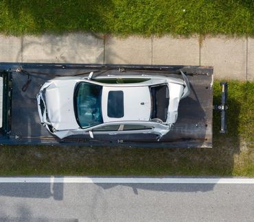 An aerial view of a car on a tow truck