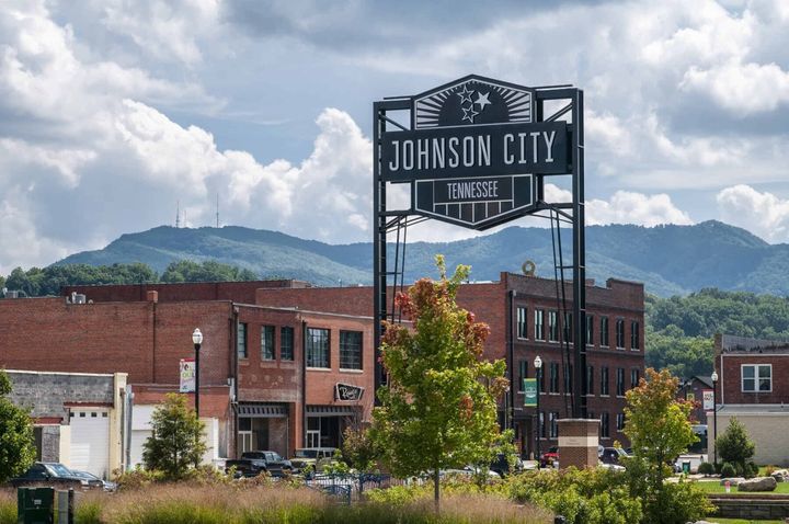 A sign for johnson city is in front of a brick building