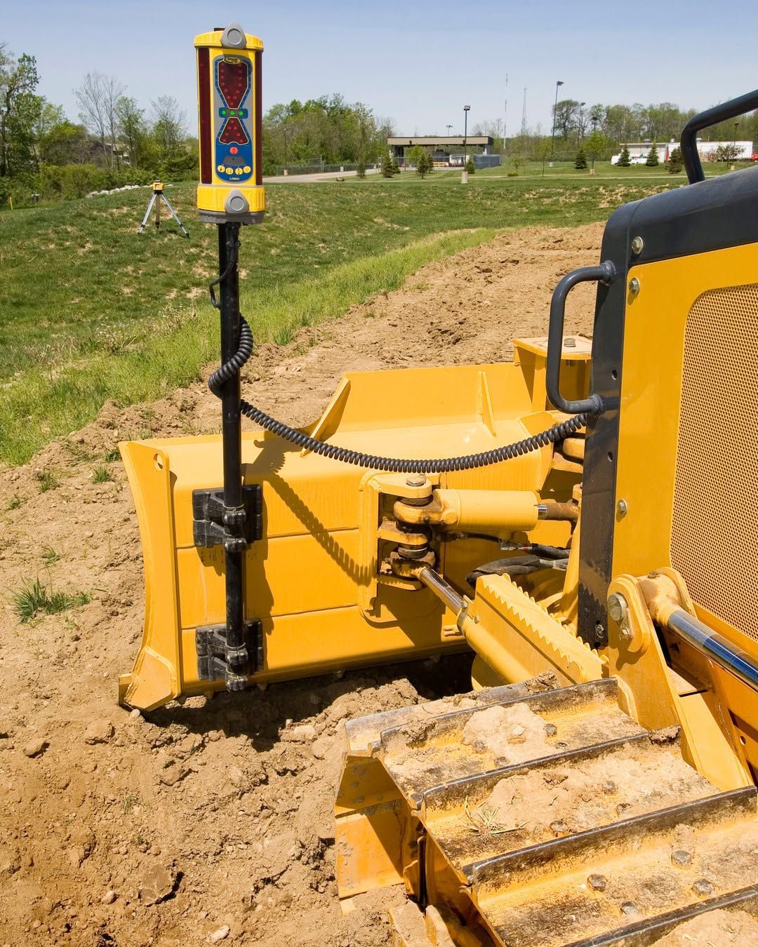 Yellow bulldozer with a GPS receiver on a construction site.