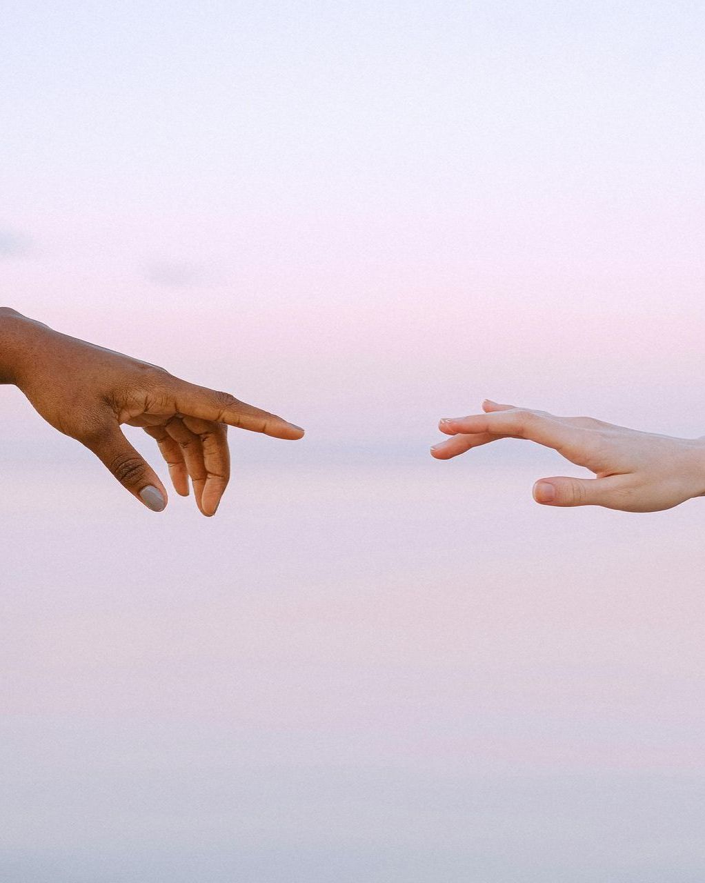 Two hands are reaching out towards each other.