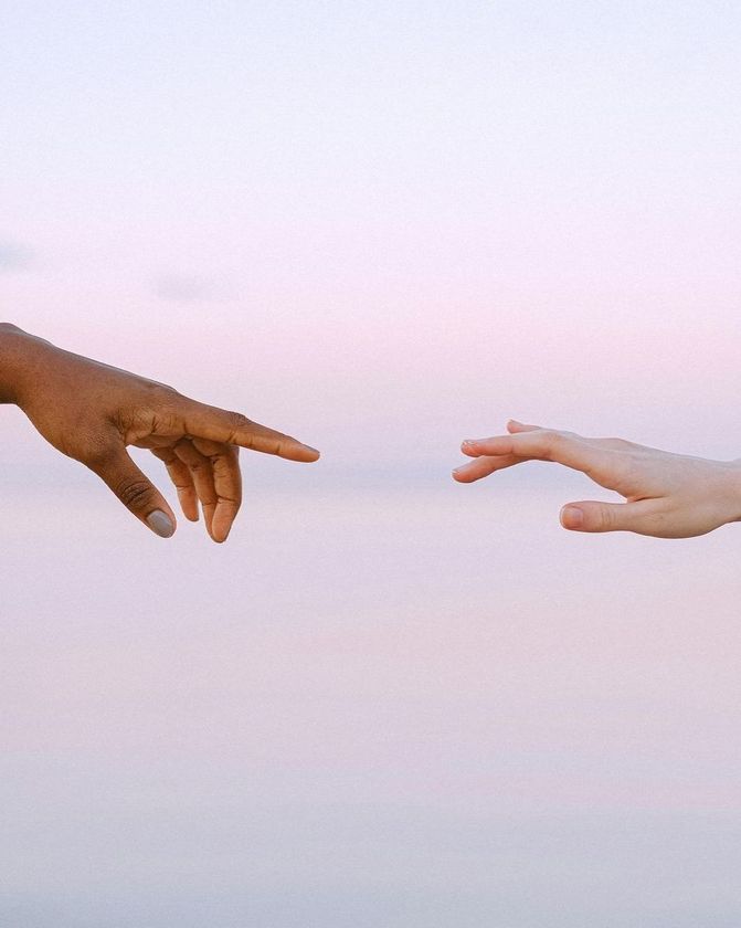 Two hands are reaching out towards each other.