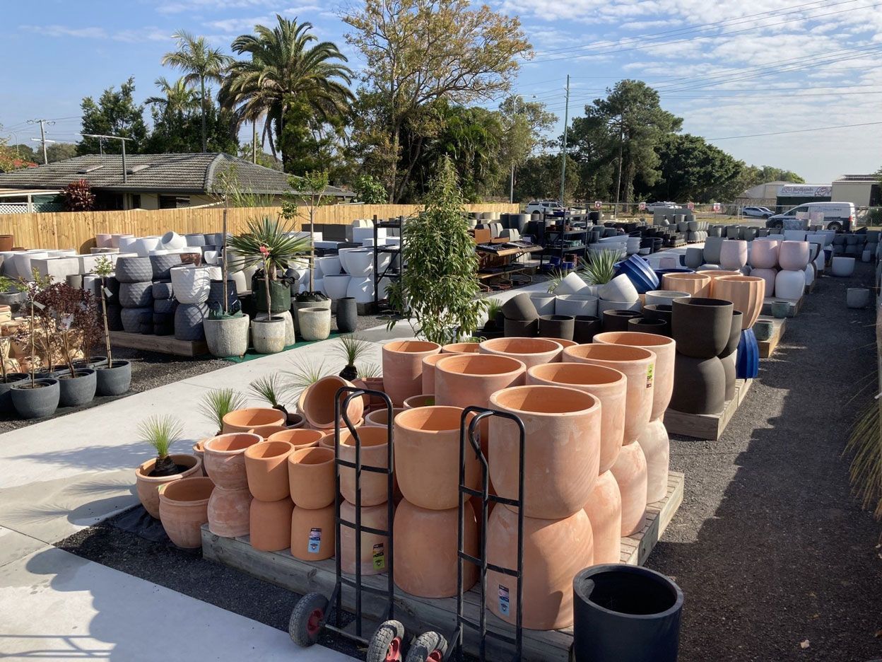 Assorted pots, varying in size, shape, and color, arranged neatly in a row.