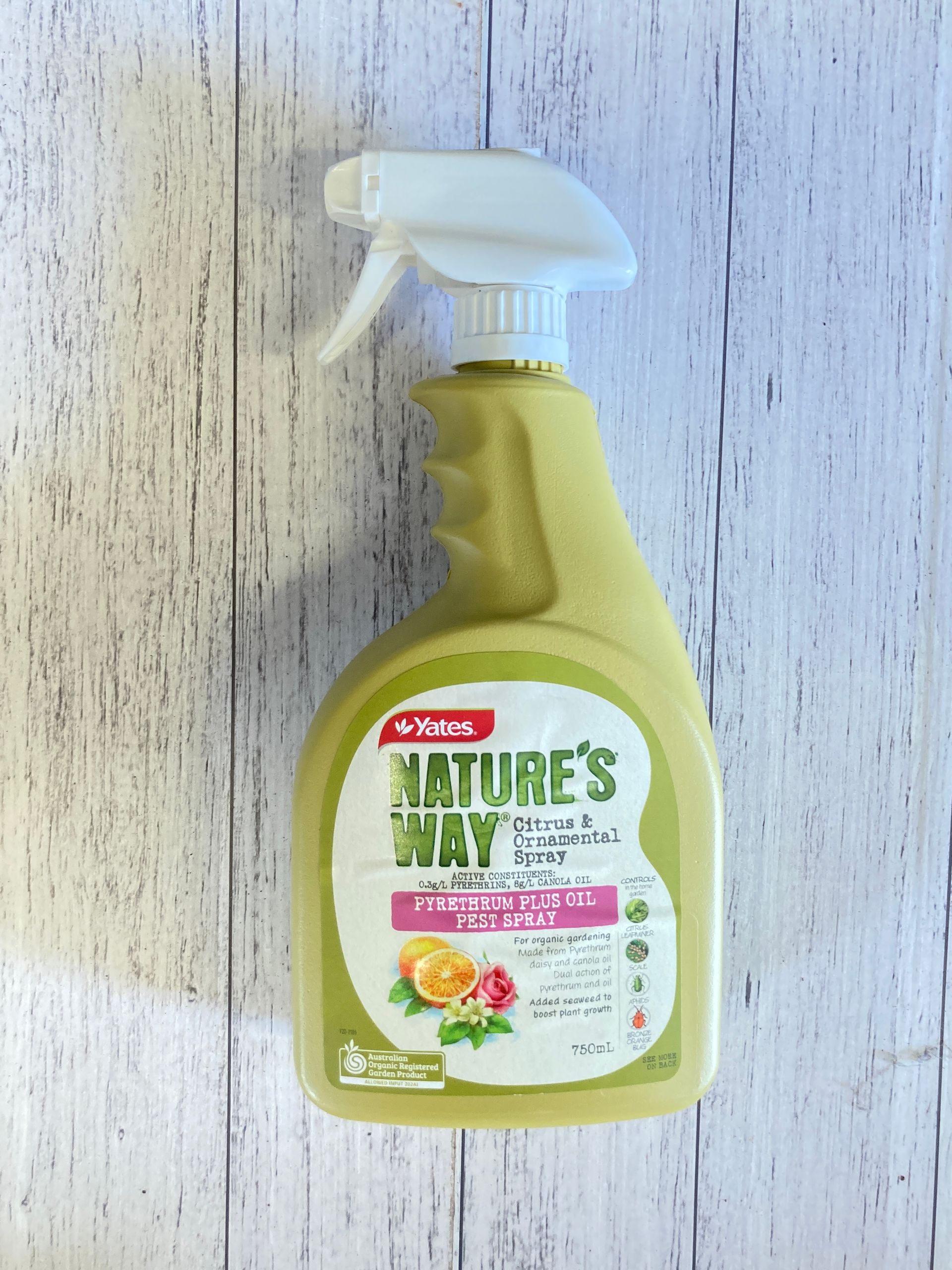 A spray bottle of nature 's way sits on a wooden table