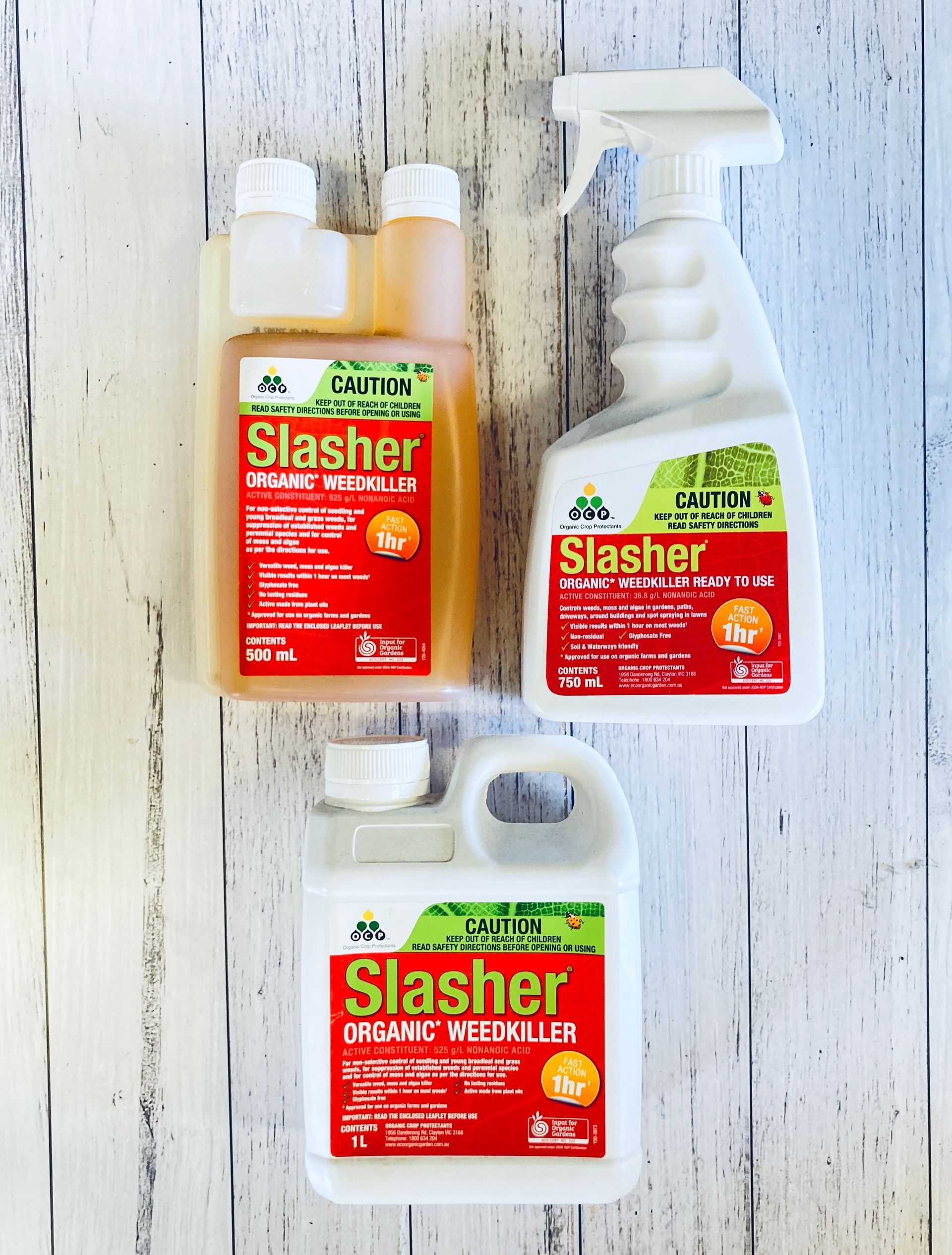 Three bottles of slasher are on a wooden table