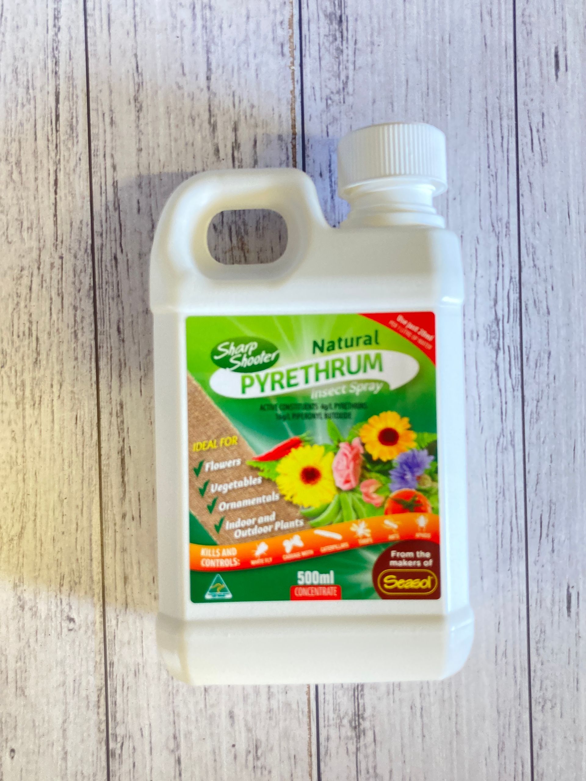 A bottle of natural pyrethrum is sitting on a wooden table