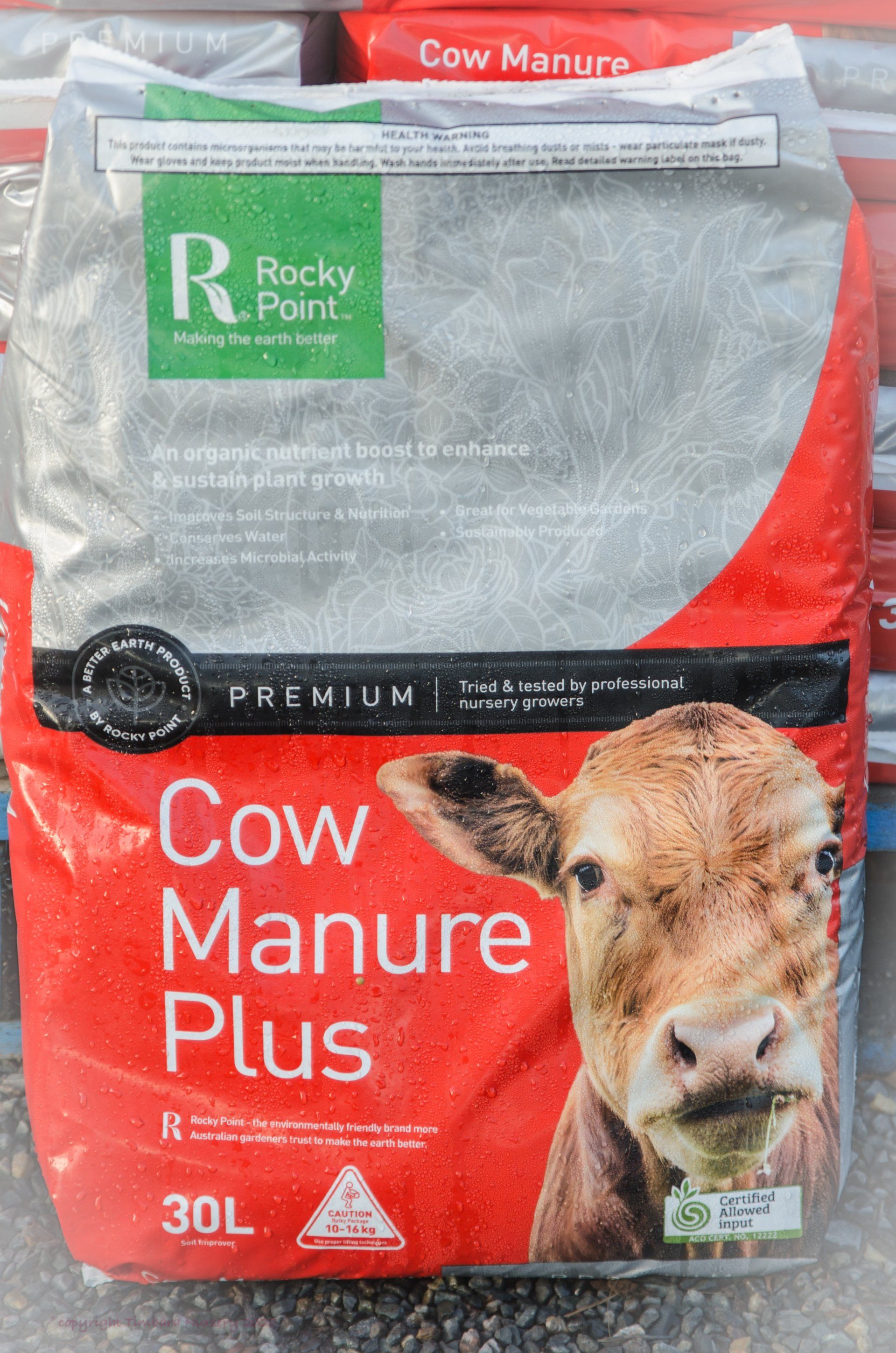 A bag of cow manure plus with a picture of a cow on it.