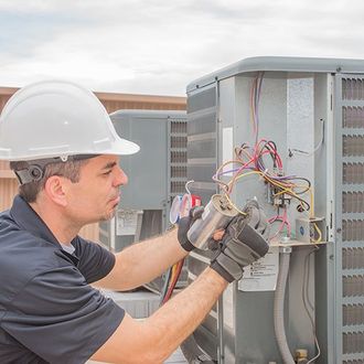 HVAC technician working on a capacitor part for condensing unit
