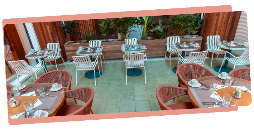 mejores restaurantes en san andres con mesas servidas, sillas tejidas y ambiente rodeado de vegetación.