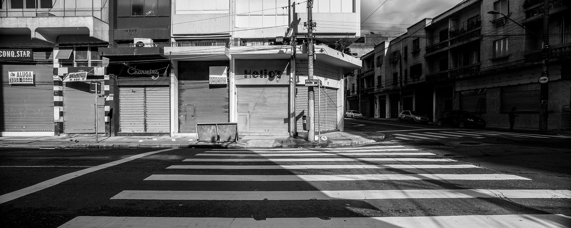 Uma foto em preto e branco de uma rua vazia com faixa de pedestres.