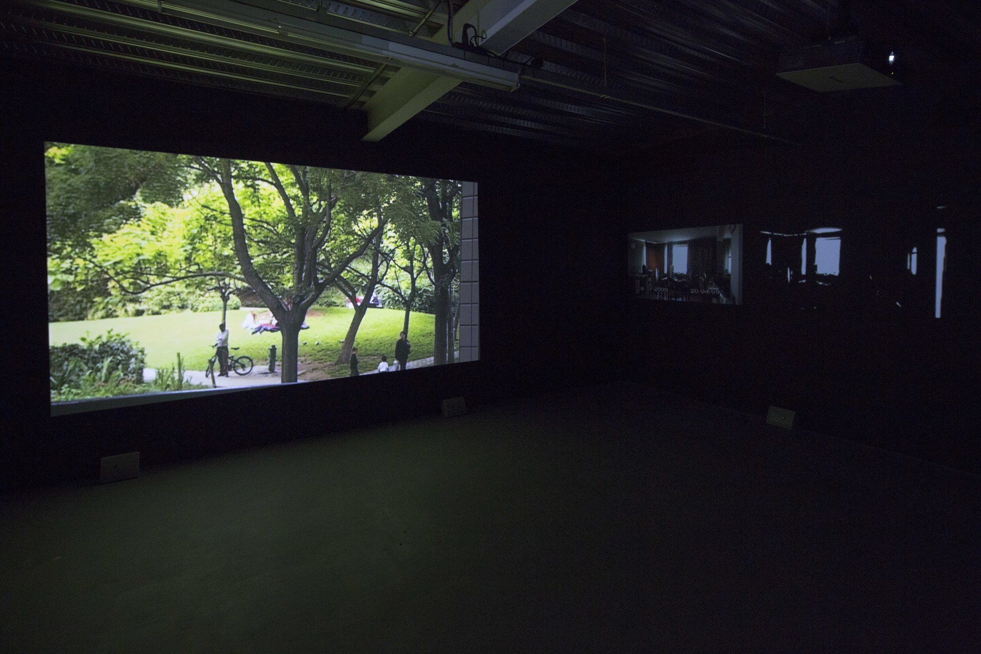 Um quarto escuro com uma tela grande mostrando um parque