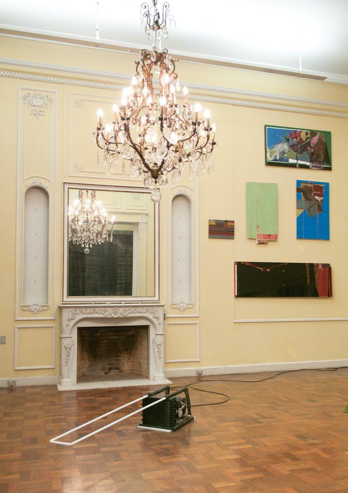 Uma sala com lareira e um lustre pendurado no teto.